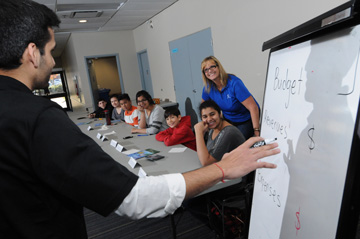 Coast Capital Savings employees explain budgeting concepts to youth attending a public delivery of Dollars with Sense at Guildford Library, Surrey, BC on November 15, 2014.